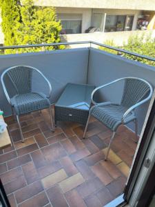 two chairs and a table on a patio at Apartment Nähe Flughafen und Messe in Ostfildern