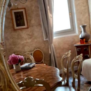 a dining room table with a vase of flowers on it at B&B La Sbàgera in Stagno Lombardo +21 photos