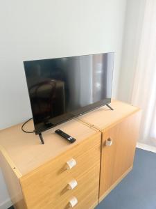 a flat screen tv sitting on top of a wooden dresser at Casa vacanze Montaldo in Bordighera