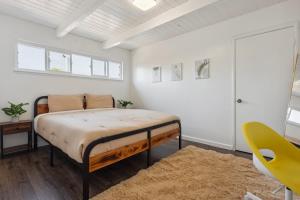 een slaapkamer met een bed en een gele stoel bij UC Proximity - Cozy City Stay - Free Parking Spot in Berkeley