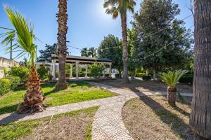 una passerella attraverso un parco con palme di I Giardini del Cavaliere a Porto Cesareo