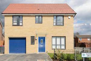 a brick house with blue doors and a red roof at Riverside Villas in Manchester