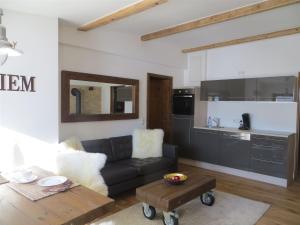 a living room with a couch and a kitchen at Bergromantik Ferienwohnung Nesterl mit eigener Sauna und Bergblick in Marktschellenberg