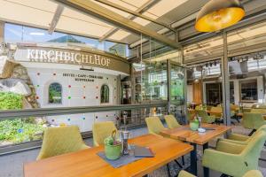 a restaurant with wooden tables and yellow chairs at Kirchbichlhof GmbH in Hippach +58 photos