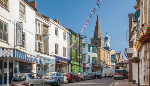eine belebte Stadtstraße mit auf der Straße geparkt in der Unterkunft 2 bedroom cottage in Kingsbridge in Kingsbridge