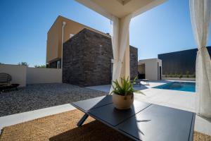 a patio with a table and a swimming pool at Vacation House Privlaka in Privlaka