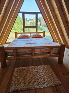a bed in a room with a large window at Malii Rajj Žabljak in Žabljak
