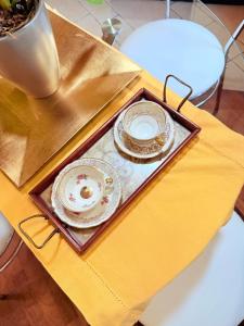 a tray with two plates on a table at Gritti Palace Morcote - Salvia - Loft by the lake with view of Morcote's church in Morcote