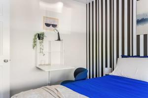 a bedroom with a bed and a blue chair at Chic Abode In Central Berkley in Berkeley