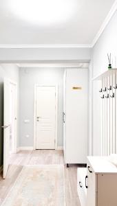 a white kitchen with a white door and a chandelier at Cozy Almaty Escape in Almaty
