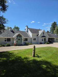 a large white house with a rock in the yard at Brookvale in Wellingtonbridge