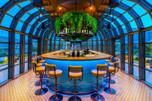 a room with a bar with chairs and a fountain at Kimpton BEM Budapest by IHG in Budapest