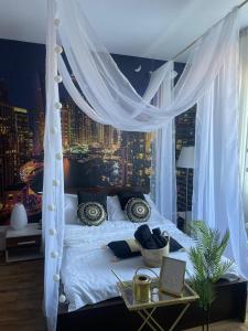 a bedroom with a white canopy bed with a city skyline at City Tales Residence in Braşov