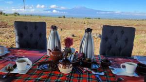 a table with a table cloth with cups and utensils at Amanya Star Bed Amboseli in Amboseli