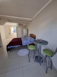a bedroom with a bed and a table and chairs at Quarto com banheiro na cidade do Cristo in Encantado