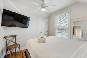 Un dormitorio con una cama y un televisor en la pared. en The Livery on 5th, Unit B, en Nashville