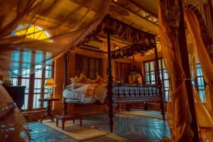 1 dormitorio con cama con dosel en una habitación con ventanas en Bari Kothi Heritage Hotel, en Murshidābād 11 fotos más
