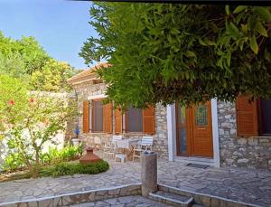 a house with a patio with a table and chairs at Agora Serenity Retreat in Pythagoreio