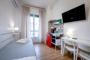 Una pequeña habitación con una cocina roja y un escritorio. en Florence smart rooms, en Florencia