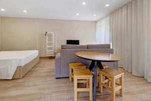 a bedroom with a bed and a table and a couch at Sidro House - Alojamento No Gerês in Geres