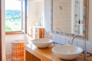 2 lavandini su un bancone in legno in bagno di Casa del Sud a Ostuni Altre 64 foto