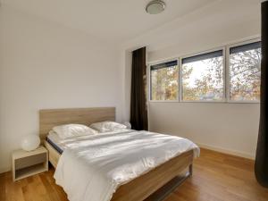 a bedroom with a large bed and two windows at Appartement de standing 8 pers, hyper centre Arcachon, balcon, parking privé, proche plages et gare - FR-1-474-28 in Arcachon