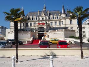 a large building with cars parked in front of it at Appartement de standing 8 pers, hyper centre Arcachon, balcon, parking privé, proche plages et gare - FR-1-474-28 in Arcachon