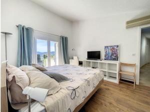 a bedroom with a large bed and a television at Charming Villa with stunning sea views in Mougins +55 photos
