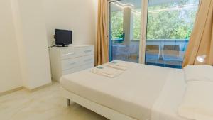 a bedroom with a bed and a tv and a window at Relais du Lac Village - Italian Homing in Desenzano del Garda +270 photos