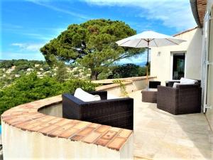 a patio with two couches and an umbrella at Charming Villa with stunning sea views in Mougins