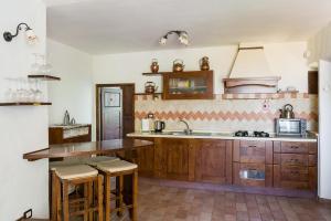 a kitchen with wooden cabinets and a sink at Ermione in Castiglione dʼOrcia +27 photos