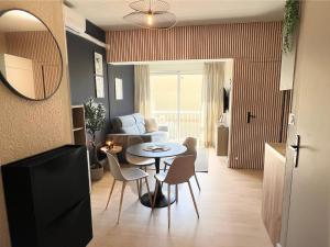 a living room with a table and chairs at Studio Valmar, accès plage 150m in Valras-Plage