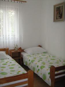 two twin beds in a room with a window at Jarmila in Rogoznica