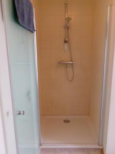 ein Badezimmer mit Dusche mit Glastür in der Unterkunft b&b Kraaiberg in Heuvelland