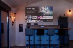 a bar with four blue bar stools in a room at 36 2 l air marin Penthouse Netflix Clim Free park Navette Grands Buffets Accès direct autoroute et plages in Narbonne