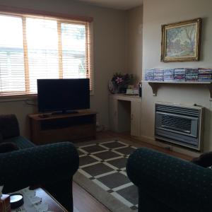 a living room with a television and a fireplace at Lillymay Cottage in Broken Hill