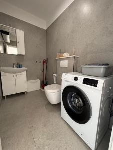 a bathroom with a washing machine and a toilet at Apartment Ivi, Omis in Omiš +2 photos