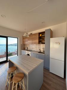 a kitchen with a refrigerator and a table with stools at Apartment Ivi, Omis in Omiš