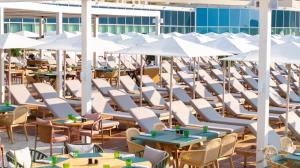 an outdoor patio with tables and chairs and umbrellas at Rixos Premium Dubrovnik in Dubrovnik