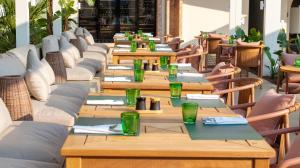 a row of wooden tables with green glasses on them at Rixos Premium Dubrovnik in Dubrovnik