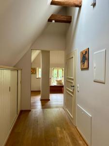 an attic room with white walls and wooden floors at Hof Allerniederung in Häuslingen +9 photos