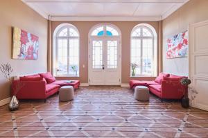 a living room with red couches and windows at Gut Pohnstorf in Alt Sührkow