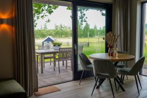 a dining room with a table and a sliding glass door at Landgoed Erve Triesthaar in De Lutte
