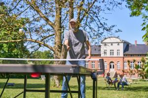 a man playing table tennis in a park at Gut Pohnstorf in Alt Sührkow