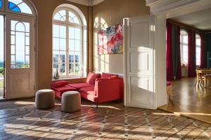 a living room with a red couch and windows at Gut Pohnstorf in Alt Sührkow