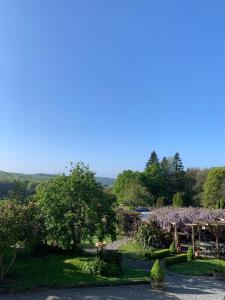 a garden with trees and purple flowers on it at Hidden gem! boho glamping tent with pool and hot tub in Berné
