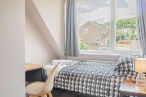 a bedroom with a bed and a desk and a window at 4 Bed House Perfect for Contractors - Families and Relocation in Stoughton