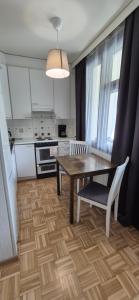 a kitchen with a wooden table and a dining room at Studio at Tottinkatu in Savonlinna