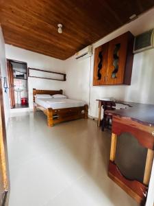 a room with a bed and a desk in it at Hostal Hilltop Capurgana in Capurganá