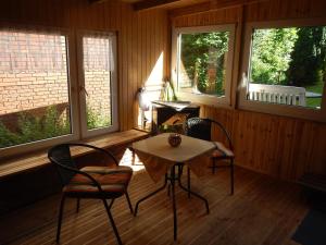a room with two chairs and a table and two windows at Ferienwohnung Kornew in Dornum